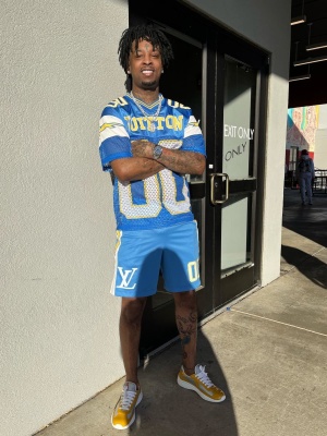 21 Savage Wearing A Louis Vuitton Light Blue And Yellow Football Jerser With Louis Vuitton Shorts And Prada Patent Yellow Sneakers