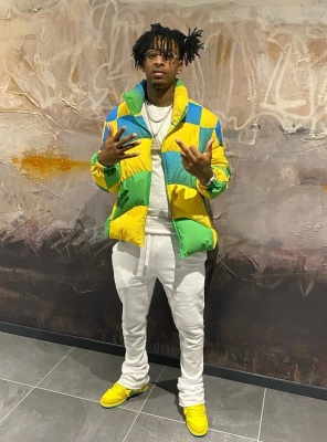 21 Savage Wearing A Yellow Checkerboard Puffer With Nike X Grateful Dead Sneakers
