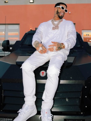Anuel Wearing Dior Sunglasses With An Amiri White Allover Logo Hoodie Amiri Mx1 Jeans And Reebok Sneakers