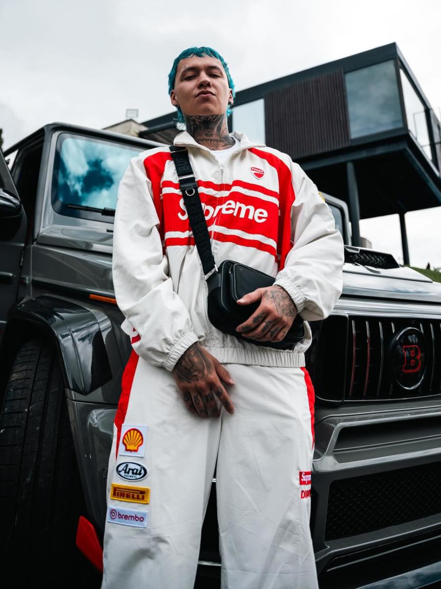 Blessd: Supreme White Racing Jacket + Trackpants, Burberry Bag & LV Skate Sneakers