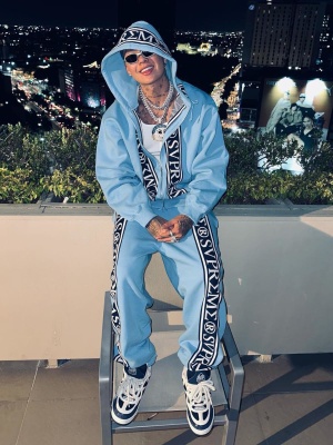 Blessd Wearing A Supreme Roman Logo Hoodie And Sweatpants With Lv Skate Sneakers