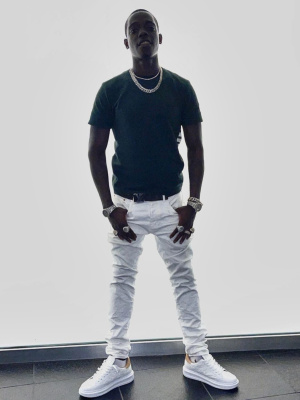 Bobby Shmurda Wearing A Thom Brown T Shirt With A Louis Vuitton Belt And Sneakers