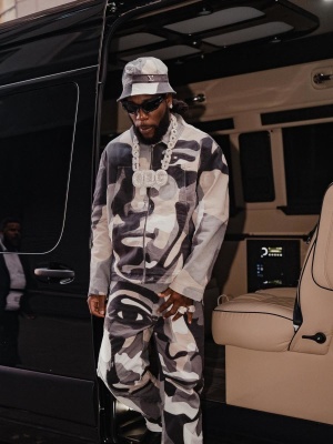 Burna Boy Wearing A Louis Vuitton Portrait Bucket Hat Denim Jacket And Jeans With Givenchy Sunglasses