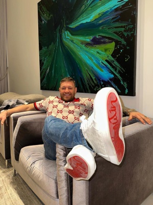 Conro Mcgregor Wearing A Gucci White And Red Gg Polo With Blue Jeans And Louboutin Sneakers