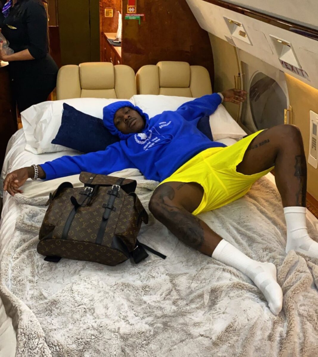 DaBaby Relaxes On The Jet In A Balenciaga WFP Hoodie & LV Backpack