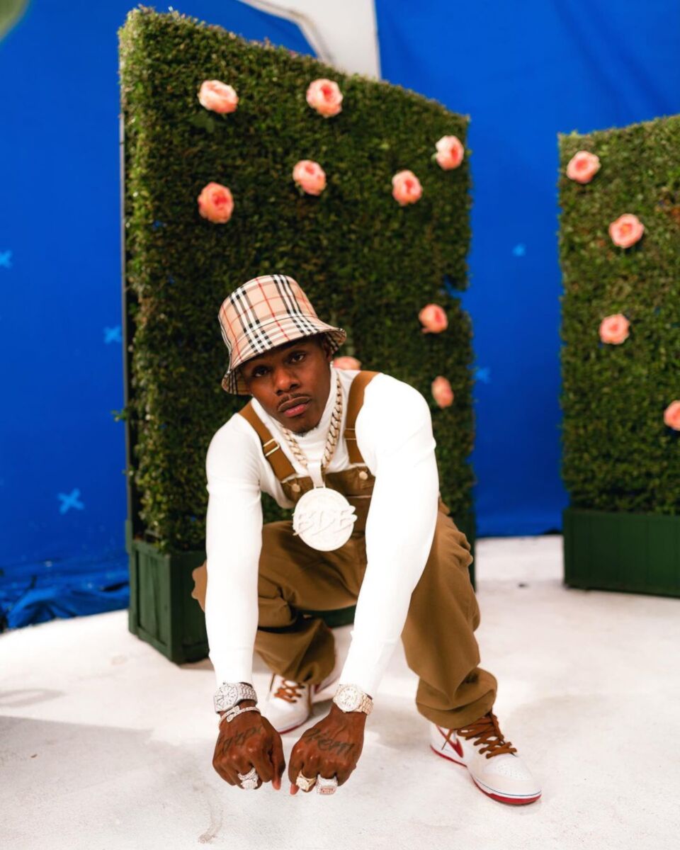 DaBaby Posing In a Burberry Bucket Hat, Dickies Overalls & High-Top Nike Dunks