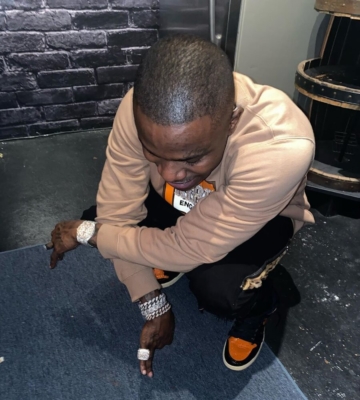 Dababy Wearing A Burberry Shirt With Amiri Jeans And Black And Orange Jordans