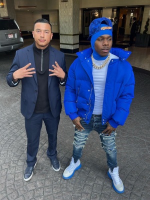 Dababy Wearing An Alexander Mcqueen Royal Blue Puffer Jacket With Amiri Indigo And Blue Plaid Jeans And Alexander Mcqueen White And Blue Sole Boots