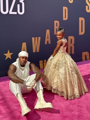 Dababy Wearing An Issey Miyake White Pleated Tank Top And Cropped Pants With Bottega Boots