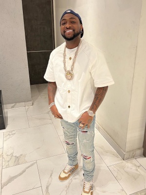 Davido Wearing A Louis Vuitton White Baseball Shirt With Amiri Clay Indigo And Red Flannel Jeans And Dior Sneakers