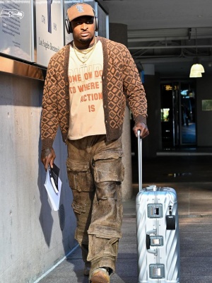 Dk Metcalf Wearing A Acne Studios Brown Diamond Cardigan Rhude Action Logo Tee Brown Leather Cargo Pants And Tumi Suitcase