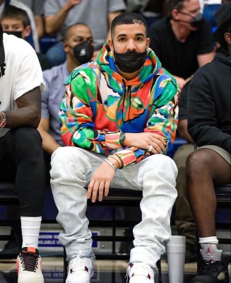 Drake Wearing A Supreme X Emilio Pucci Multicolor Hoodie With Faded Jeans And Jordan White And Metallic Red Sneakers