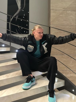 Erling Hardland Wearing A Nike X Tiffany And Co Varsity Jacket And Sneakers With Issey Miyake Pants