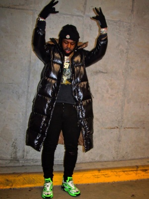 Est Gee Wearing A Moncler Black Long Puffer Coat And Beanie With Louis Vuitton Neon Green Sneakers