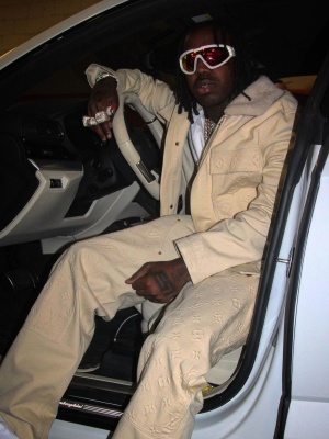 Est Gee Wearing A White Louis Vuitton Monogram Jacket And Pants With Moncler Sport Mask Sunglasses