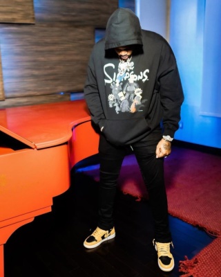 Fivio Foreign Wearing A Balenciaga X The Simpsons Hoodie With Black Pants And Jordan Black And Yellow Sneakers