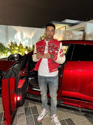 Fredo Wearing An Off White Chicago Bulls Varsity Jacket With Amiri Logo Jeans And Jordan 4 Sneakers