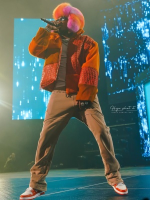 Future Wearing A Who Decides War Orange Patchwork Jacket With Beige Sweatpants And Louis Vuitton Sneakers