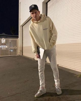 G Eazy Wering A Fear Of God Essential Hoodie White Jeans And Nike Air Yeezy 2 Sneakers