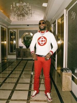 Gucci Mane Wearing Cartier Oversized Panther Sunglasses With A Casablanca Sweater Red Jeans And New Balance Sneakers