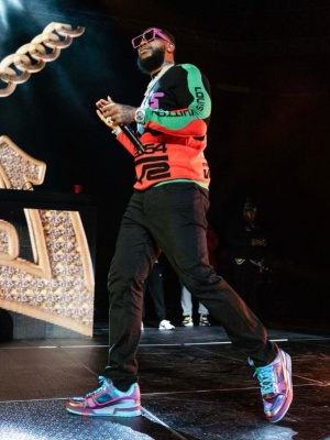 Gucci Mane Wearing Louis Vuitton Purple Sunglasses With A 5054 Sweater And Purple And Neon Blue Trainer Sneakers