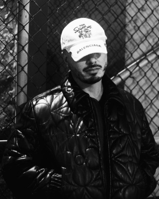 J Balvin Wearing A Balenciaga X The Simpsons Hat With A Louis Vuitton Black Leather Jacket And Nike Af1s