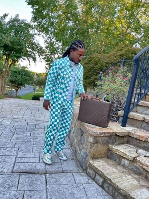 Jacquees Wearing A Louis Vuitton Light Blue And White Damier Denim Jacket With A Brown Monogram Briefcase And Metallic Sneakers