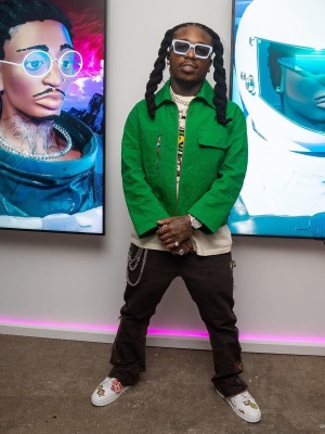 Jacquees Wearing Louis Vuitton Light Blue Sunglasses With A Green Denim Jacket And Nigo Duck Sneakers