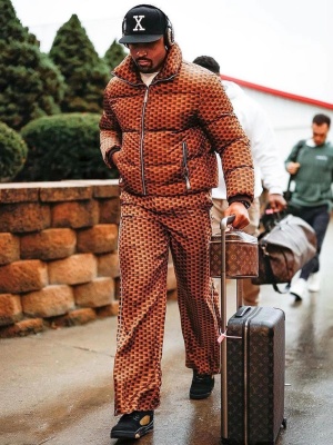 Jalen Hurts Wearing A Bally Triangle Brown Puffer And Pants With Louis Vuitton Bag And Suitcase