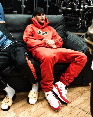 Justin Bieber Wearing A Drew House Red Hoodie And Sweatpants With Nike Air Huarache White And Red Sneakers