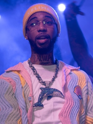 Key Glock Wearing A Celine Yellow And White Logo Beanie With A Casablanca Multicolor Pastel Wavy Shell Shirt