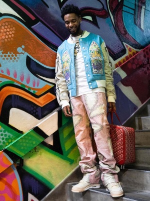 Key Glock Wearing A Who Decides War Blue Varsity Jacket With Pink Leather Pants And Jorda 4 With A Red Goyard Bag