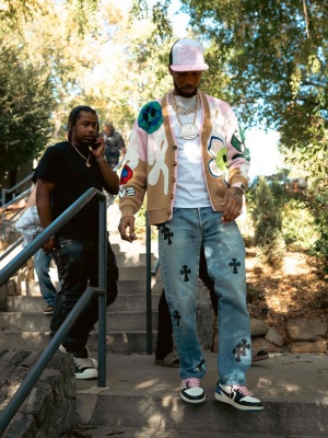 Key Glock Wearing Chrome Hearts Light Wash Blue And Black Leather Cross Jeans With A Barrow Cardian And Jordan 1s