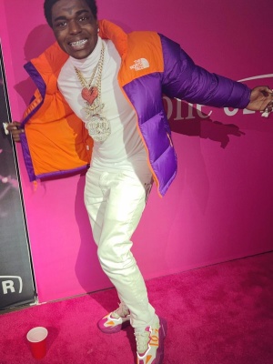Kodak Black Wearing A The North Fae Purple And Orange Puffer With Dolce And Gabbana Matching Sneakers