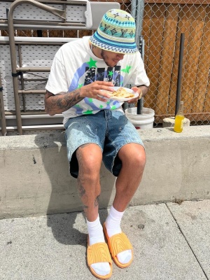 Kyle Kuzma Wearing A Lv Bucket Hat And Shorts With A Saint Mxxxxxx Tee And Crocs Slides