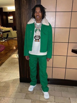 Lil Baby Wearing A Louis Vuitton Green Monogram Jacket And Jeans With A Nigo Duck Tee And Run Away Sneakers