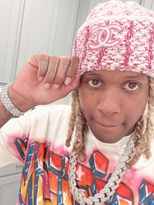 Lil Durk Wearing A Chanel Pink And White Speckled Beanie With A Louis Vuitton White Graffiti Logo T Shirt