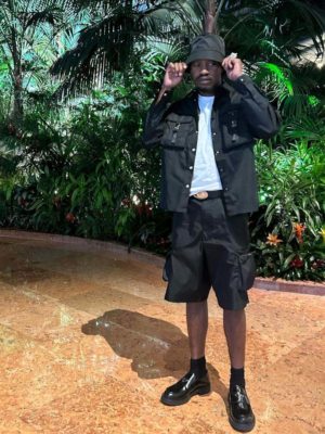 Lil Tjay Prada Bucket Hat Black Cargo Shirt Black Cargo Shorts Oval Belt Black Loafers