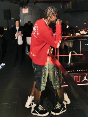 Lil Tjay Wearing A Chrome Hearts Red Cardigan Black Leather Shorts And Rick Owens Sneakers