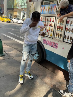 Lil Tjay Wearing A Dior Whtie And Yellow Cd Icon Hoodie With Amiri Jeans And Dior B22 Sneakers