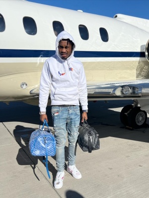 Lil Tjay Wearing A Dior X Kenny Scharf Hoodie With Amiri Jeans A Goyard Bag And A Louis Vuitton Bag