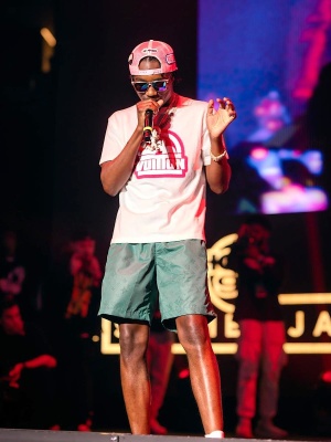 Lil Tjay Wearing A Loius Vuitton White Pink Logo Tee With Green Swim Shorts