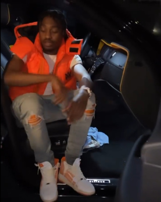 Lil Tjay Wearing An Amiri Orange Puffer Vest With Orange Cracked Paint Jeans And Orange High Top Bandana Sneakers