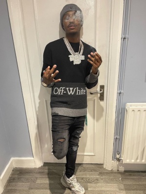 Lil Tjay Wearing An Off White Grey Beanie With A Black Colorblock Sweater Amiri Iridescent Jeans And Balenciaga Sneakers