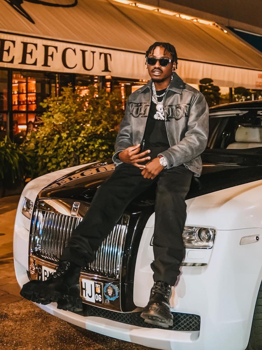 Lil TJay Sits Atop a Rolls-Royce In Marble Sunglasses & a Louis Vuitton Leather Jacket