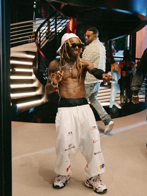 Lil Wayne Wearing A Balenciaga Clip Hat With A Shooting Sleeve White Logos Sweatpants And White Track Sneakers