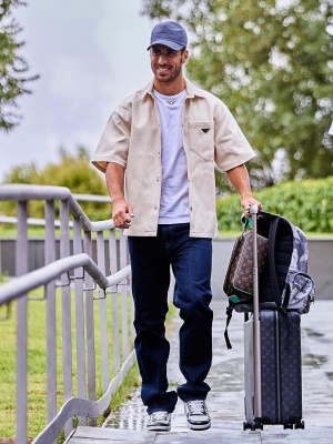 Marco Asensio Wearing A Prada Denim Shirt Logo Tee And Patent Sneakers With Louis Vuitton Dopp Kit And Suitcase