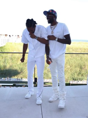 Meek Mill Wearing A Dior X Kenny Scharf T Shirt With White Jeans And Louis Vuitton Sneakers