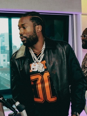 Meek Mill Wearing A Louis Vuitton Black Leather Perforated Jacket And A Black And Orange 00 Football Jersey