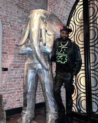 Meek Mill Wearing A Louis Vuitton Leather Jacket And Black Neon Tee With Amiri Pants